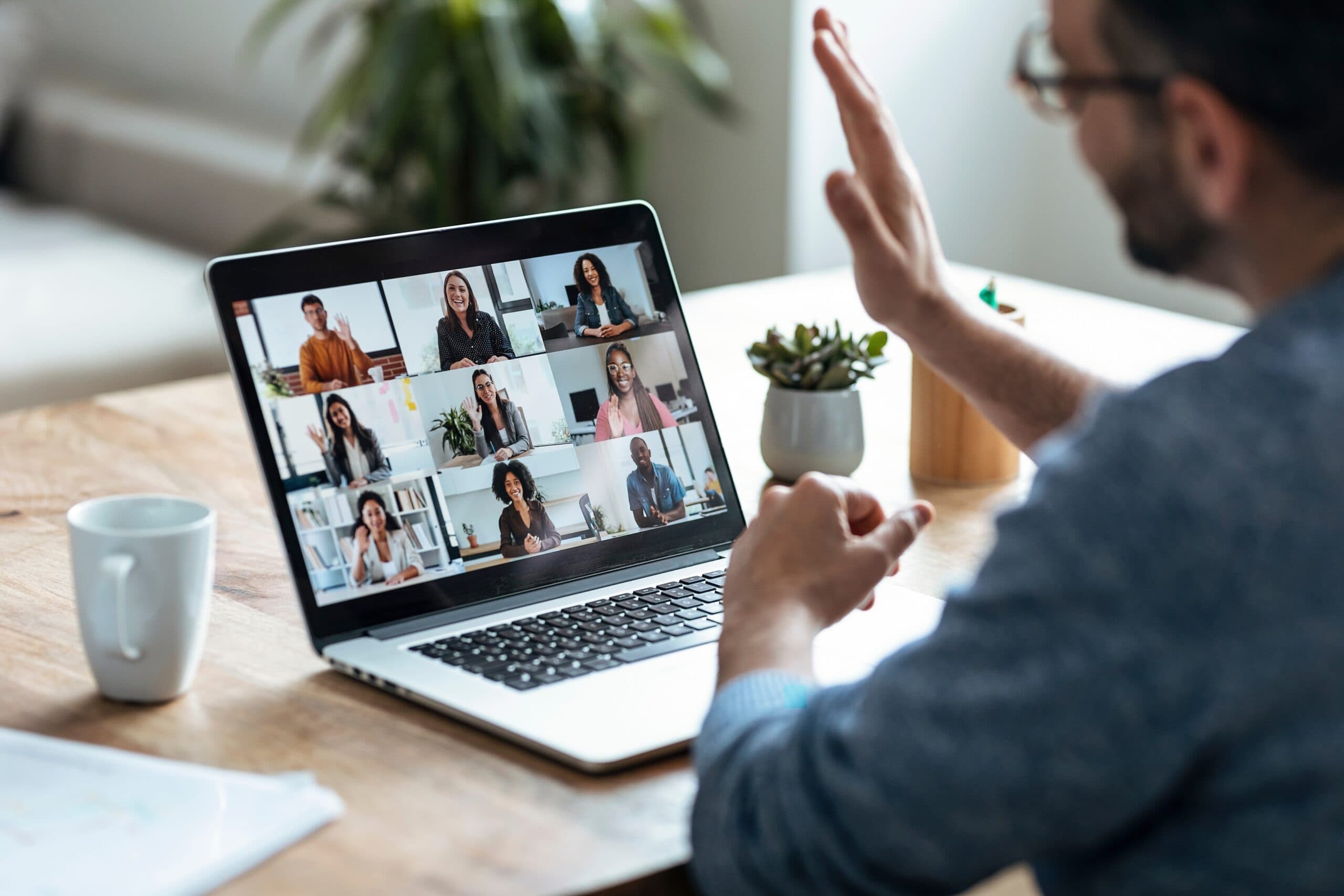 man greeting colleagues on a virtual call